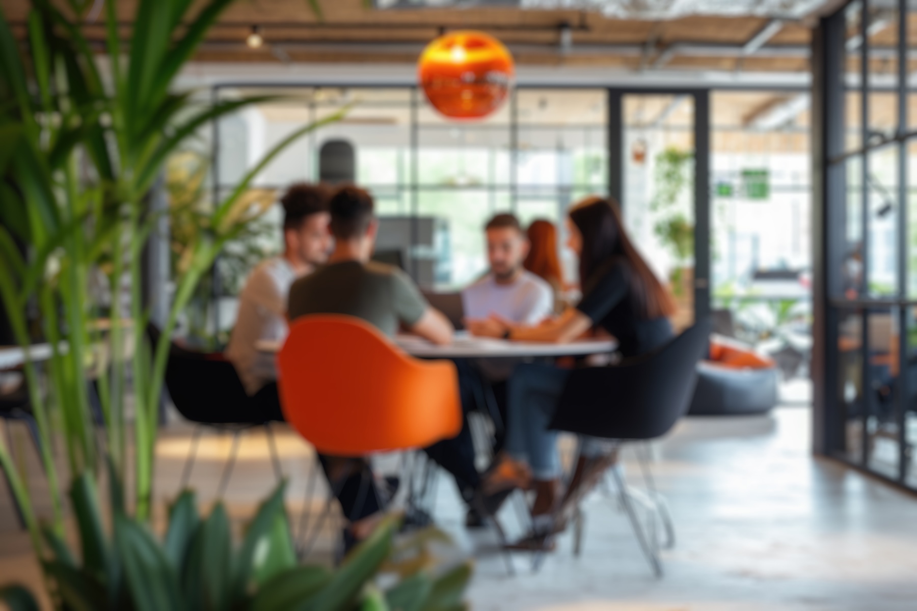 Blurred photo capturing the dynamic atmosphere of a modern open-plan office with people engaged in discussion and work.