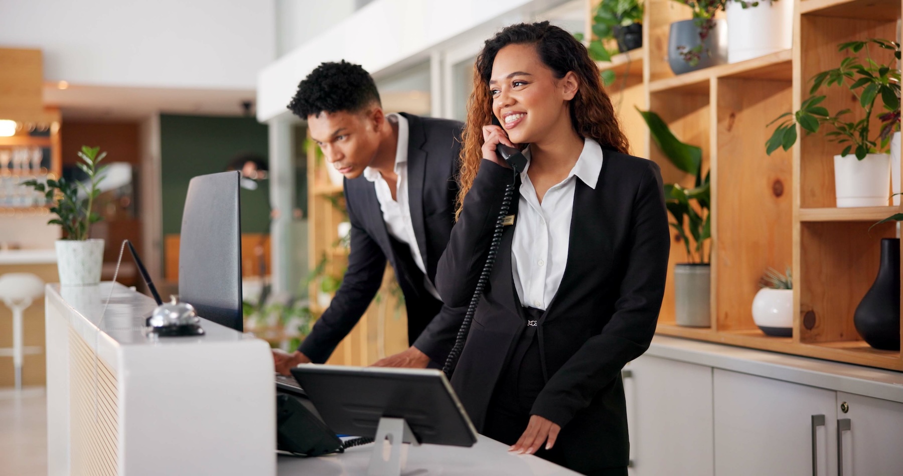 Hotel receptionist taking call at lobby check in desk