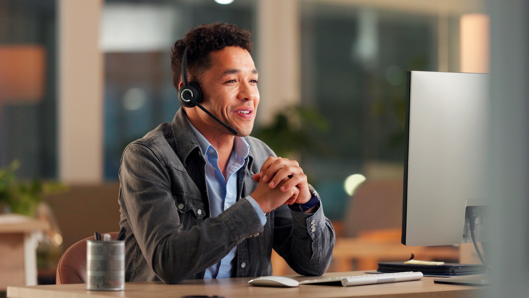 Man wearing headset for a virtual call on his computer